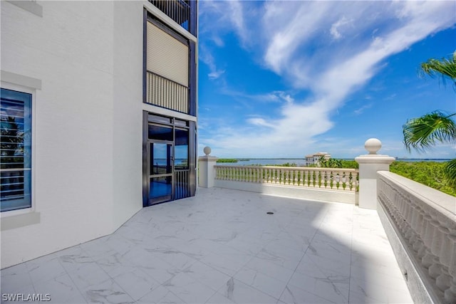 view of patio / terrace with a water view and a balcony