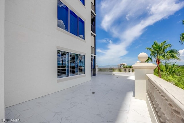 view of patio with a water view and a balcony