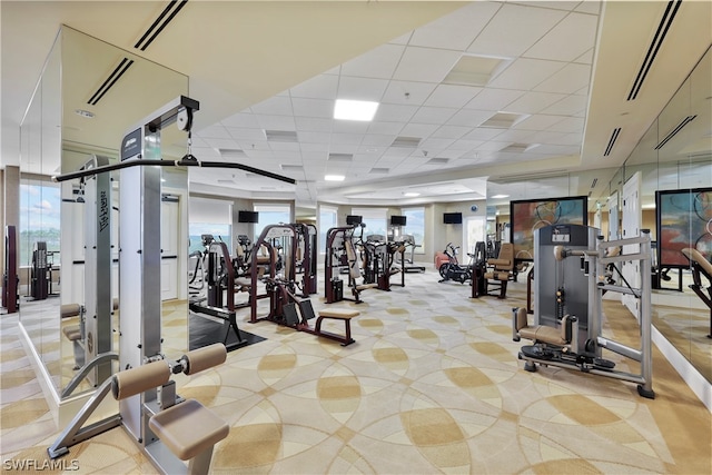 workout area featuring a paneled ceiling and plenty of natural light