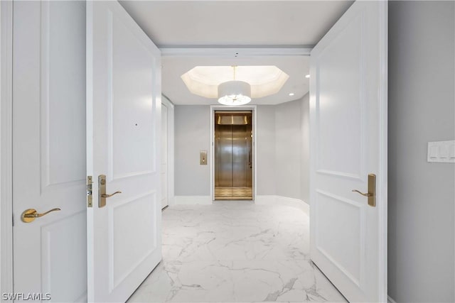 corridor with elevator and a tray ceiling