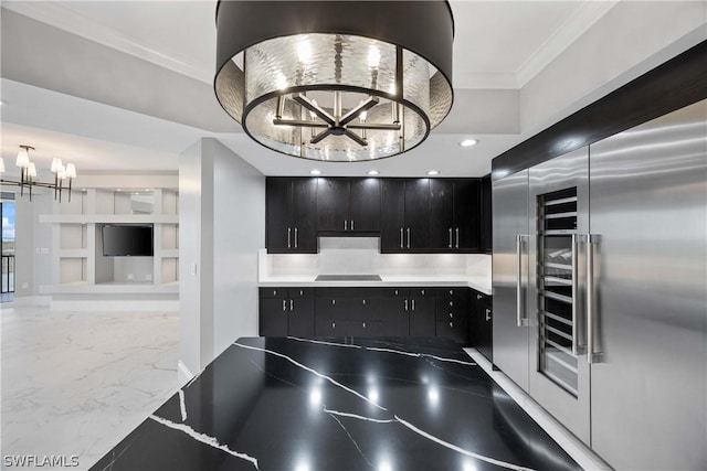 kitchen with high end fridge, black electric cooktop, crown molding, built in features, and an inviting chandelier