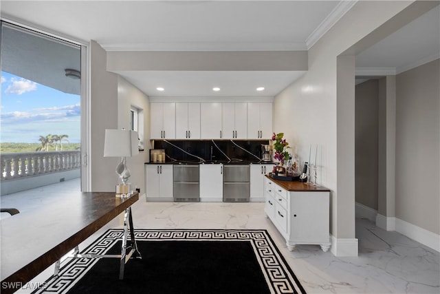 kitchen with decorative backsplash, white cabinets, baseboards, marble finish floor, and ornamental molding