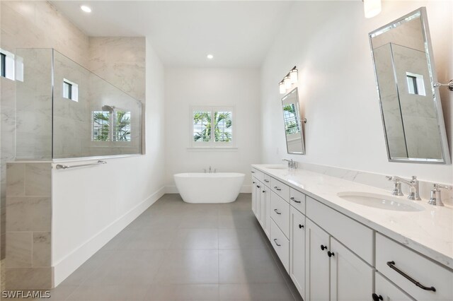 bathroom with shower with separate bathtub, vanity, and tile patterned floors