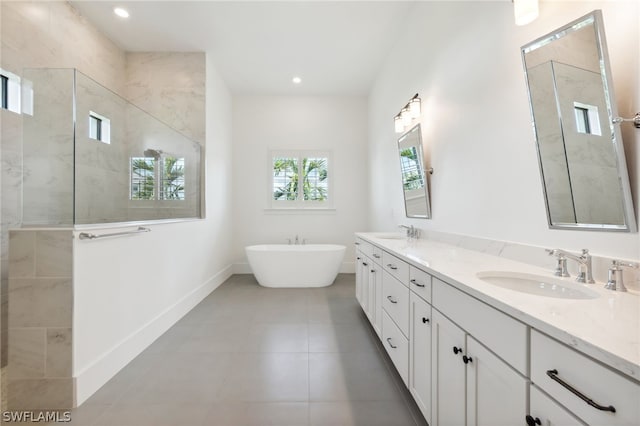 full bath featuring a sink, a freestanding tub, and tiled shower