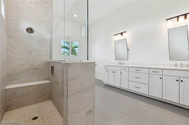 bathroom featuring tile patterned floors, vanity, and a tile shower