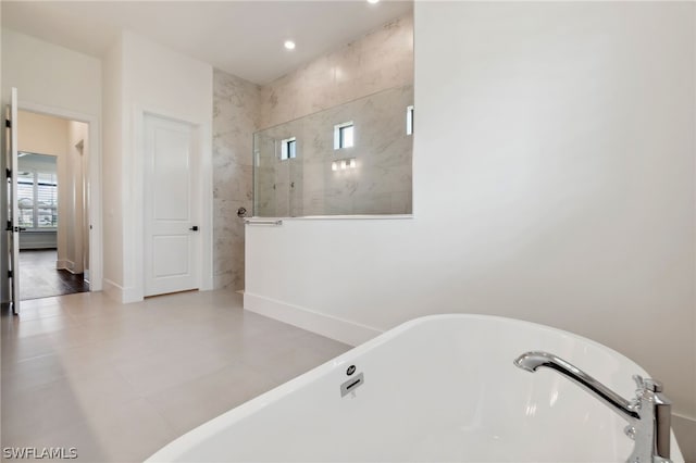 full bathroom featuring baseboards, a freestanding bath, and a walk in shower