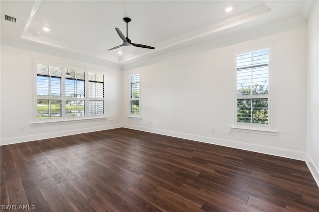 empty room featuring dark wood-style floors, visible vents, crown molding, and a tray ceiling