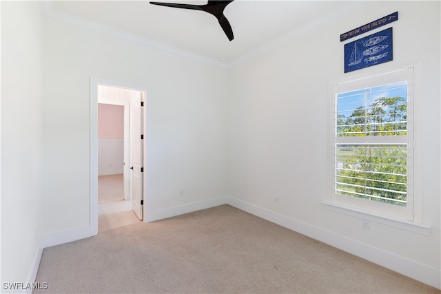 spare room featuring light carpet, crown molding, and ceiling fan