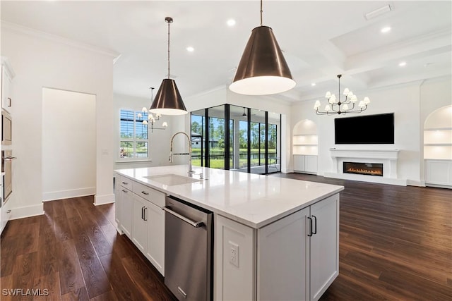 kitchen with a sink, stainless steel appliances, a lit fireplace, and an inviting chandelier