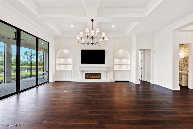 unfurnished living room featuring built in features, wood finished floors, a warm lit fireplace, ornamental molding, and a chandelier