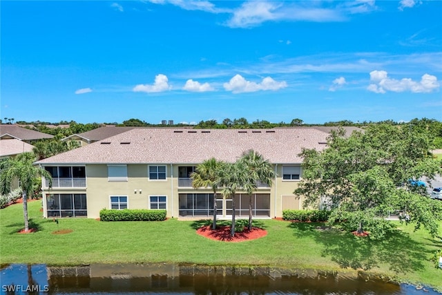 14721 Calusa Palms Dr Unit 103, Fort Myers, FL 33919 - rear view of property featuring a yard, a sunroom, stucco siding, a shingled roof, and a water view