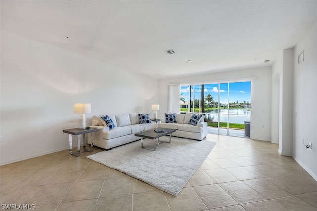 living room with a water view and light tile patterned floors