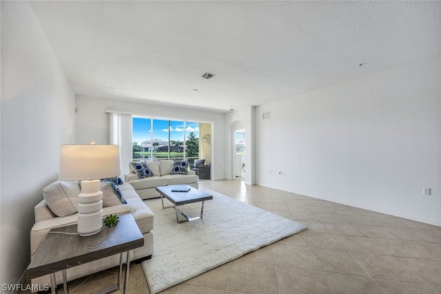 tiled living room featuring a textured ceiling