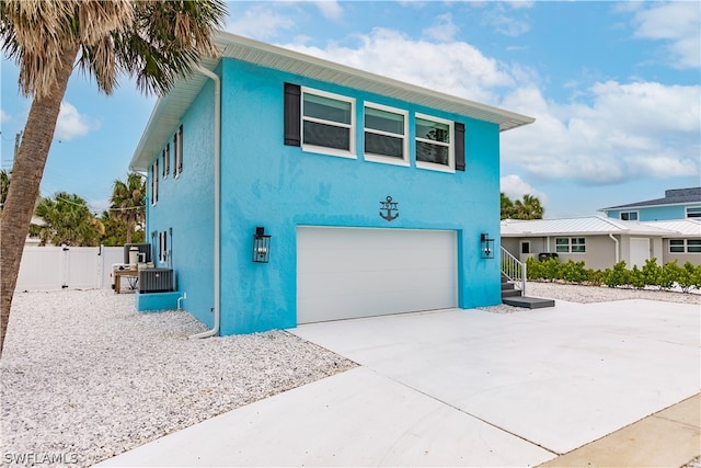 view of front of home featuring cooling unit and a garage