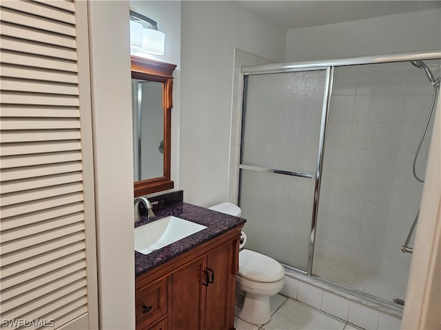 bathroom featuring vanity, an enclosed shower, tile patterned flooring, and toilet