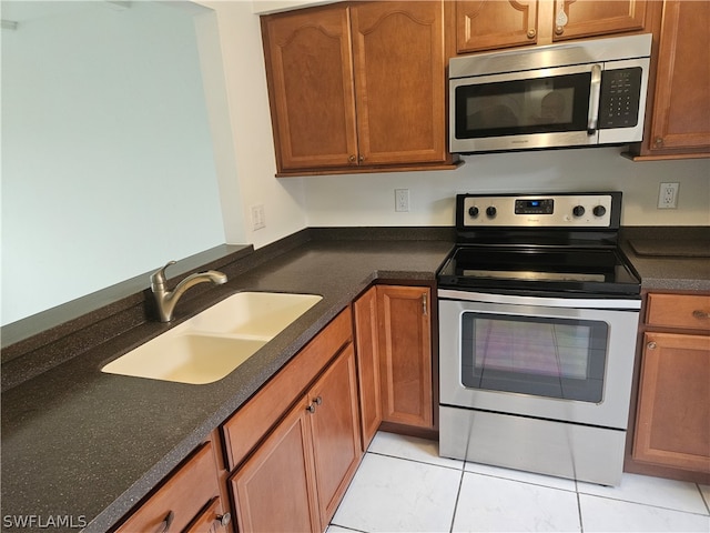 kitchen with sink, appliances with stainless steel finishes, and light tile patterned floors