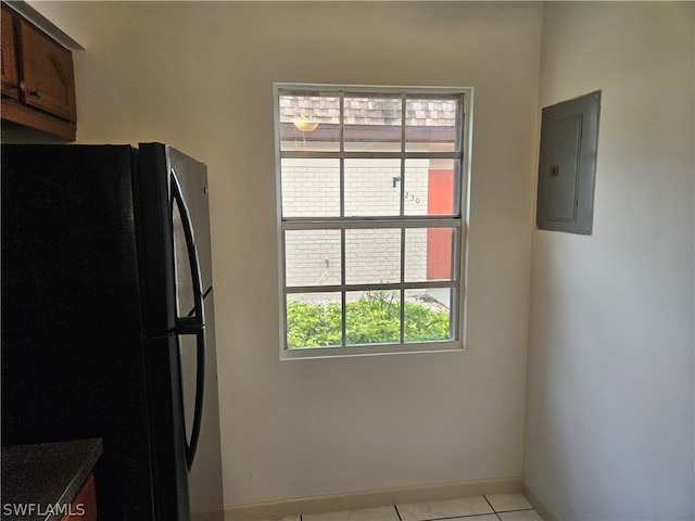 kitchen with light tile patterned flooring, fridge, and electric panel