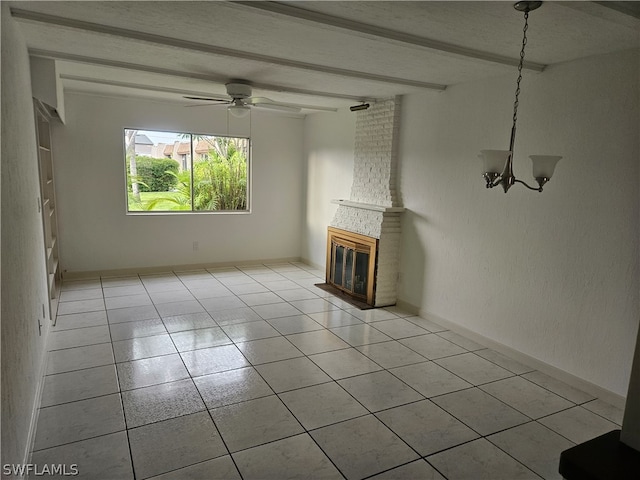 unfurnished living room featuring light tile patterned floors, a textured ceiling, ceiling fan with notable chandelier, brick wall, and a large fireplace