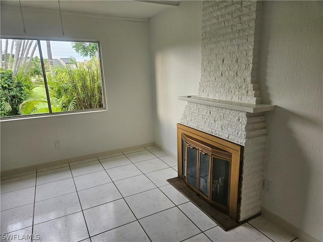 unfurnished living room featuring brick wall, a fireplace, and light tile patterned floors