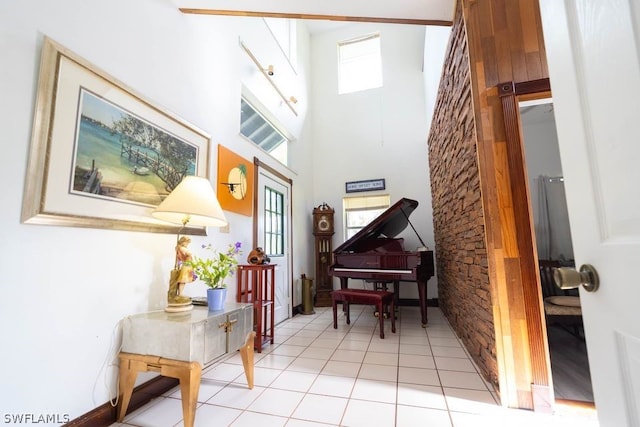 miscellaneous room featuring light tile patterned flooring and a towering ceiling