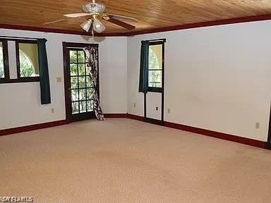 carpeted spare room with wooden ceiling and ceiling fan