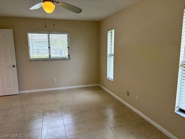 tiled empty room featuring ceiling fan