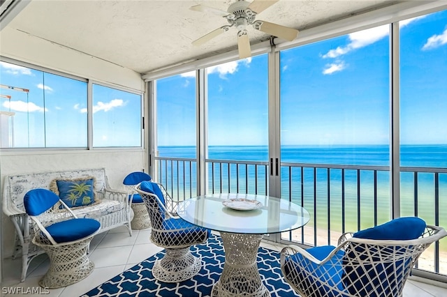 sunroom with a water view and ceiling fan