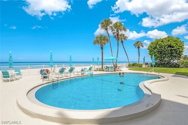 view of swimming pool with a patio and a water view