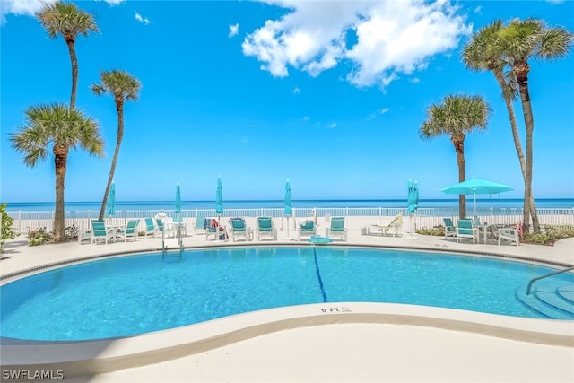 view of swimming pool with a patio and a water view