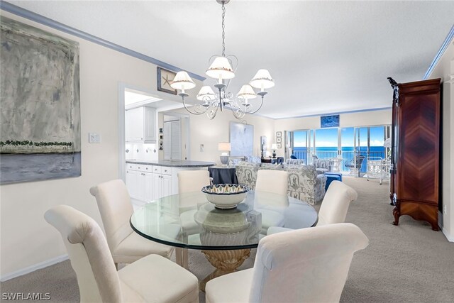 dining room featuring light carpet, crown molding, and a chandelier