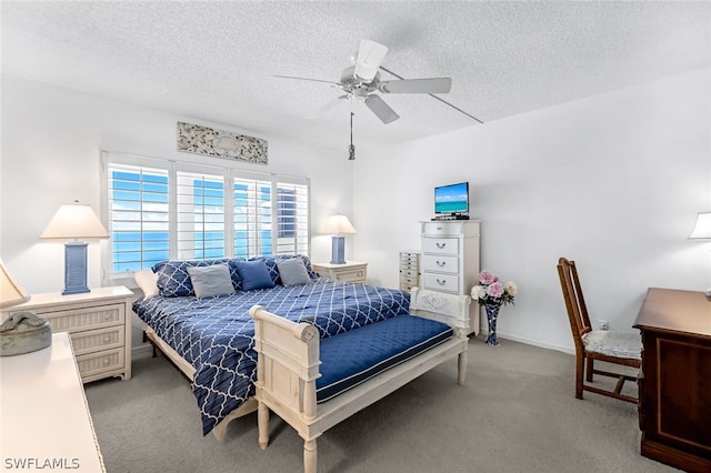 carpeted bedroom with ceiling fan and a textured ceiling