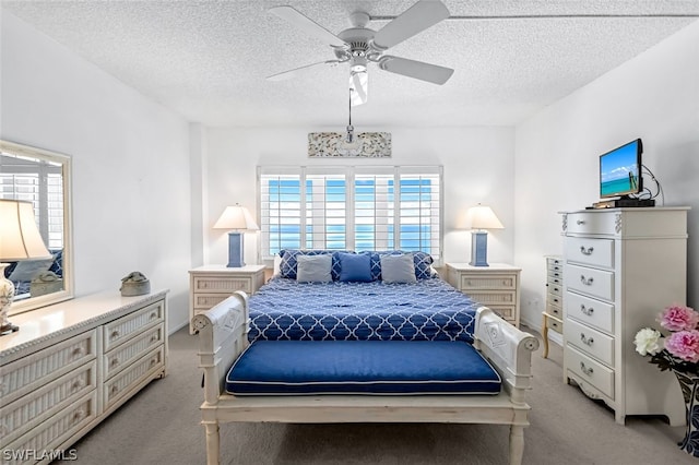 carpeted bedroom with ceiling fan and a textured ceiling