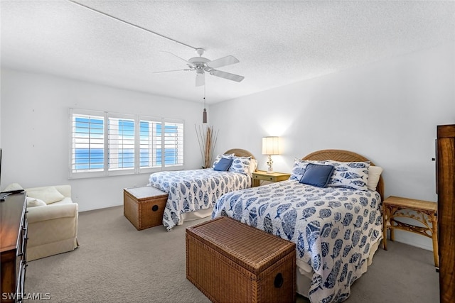 bedroom featuring ceiling fan, light colored carpet, and a textured ceiling