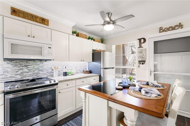 kitchen with appliances with stainless steel finishes, tasteful backsplash, white cabinets, crown molding, and ceiling fan