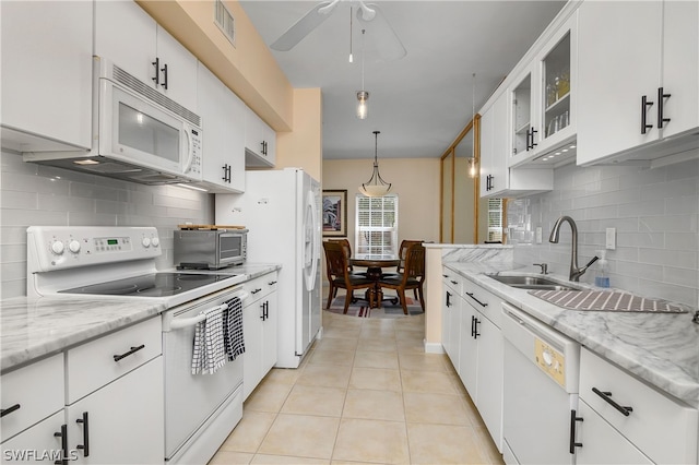 kitchen with decorative backsplash, white cabinetry, hanging light fixtures, and white appliances