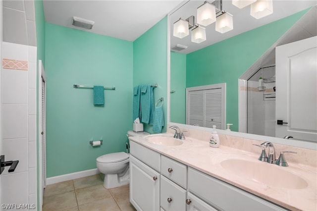 bathroom with dual vanity, tile patterned floors, and toilet