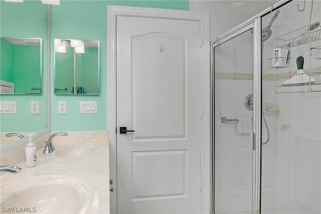 bathroom featuring an enclosed shower and dual bowl vanity