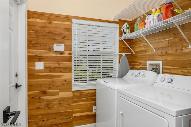 washroom with wood walls and separate washer and dryer