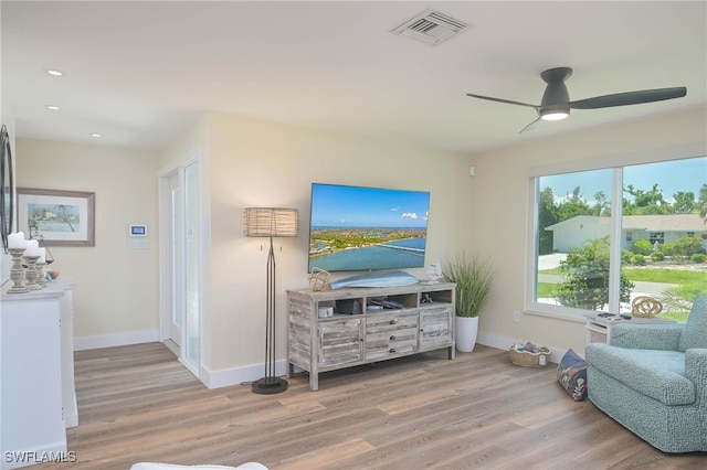 living area with light wood-type flooring and ceiling fan