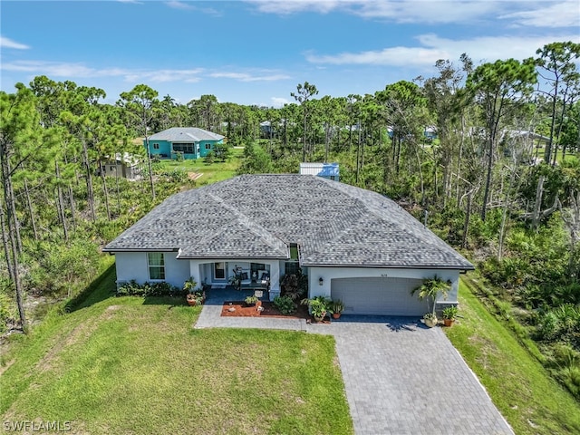 ranch-style home featuring a garage, covered porch, and a front lawn