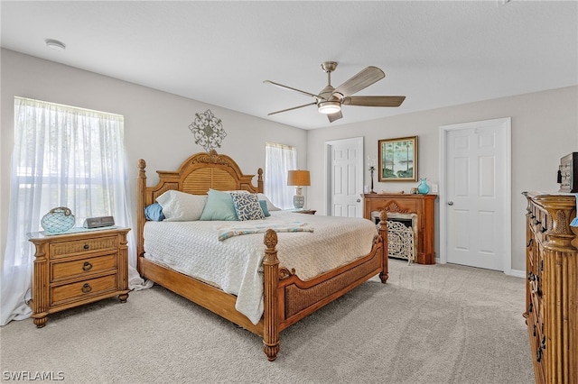 carpeted bedroom featuring ceiling fan and multiple windows