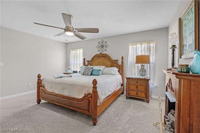 bedroom featuring multiple windows, light carpet, and ceiling fan