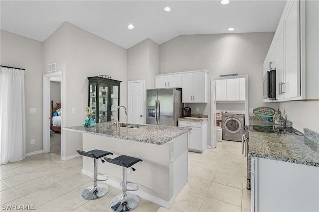 kitchen featuring white cabinetry, sink, washer / dryer, and stainless steel appliances