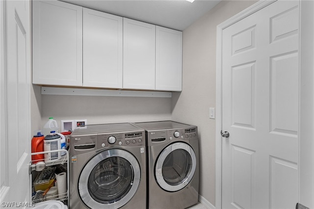 laundry area featuring washer and clothes dryer and cabinets