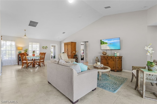 tiled living room featuring high vaulted ceiling