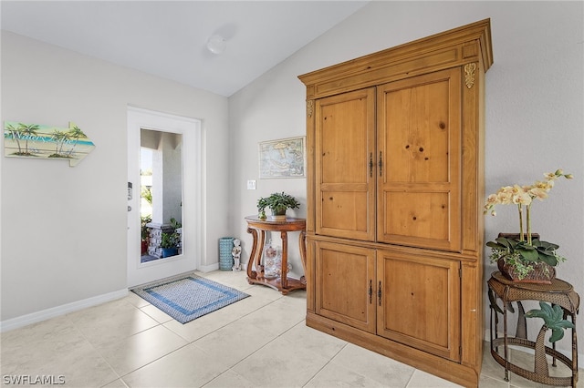 doorway to outside featuring vaulted ceiling and light tile patterned floors