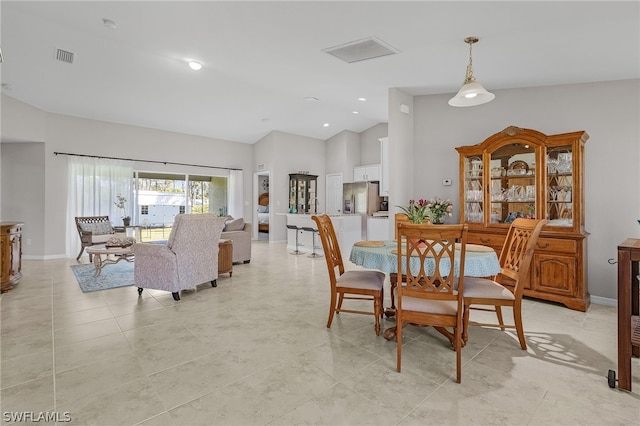 dining area with lofted ceiling and light tile patterned flooring