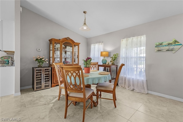 tiled dining room with wine cooler and vaulted ceiling