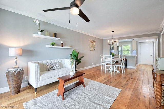 living room featuring ornamental molding, ceiling fan with notable chandelier, and light hardwood / wood-style flooring