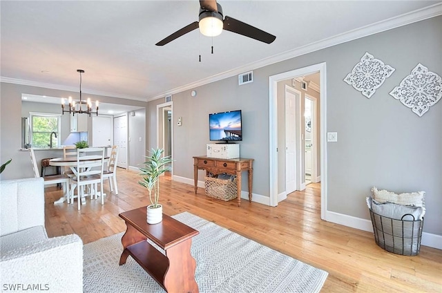 living room with crown molding, sink, ceiling fan with notable chandelier, and light wood-type flooring